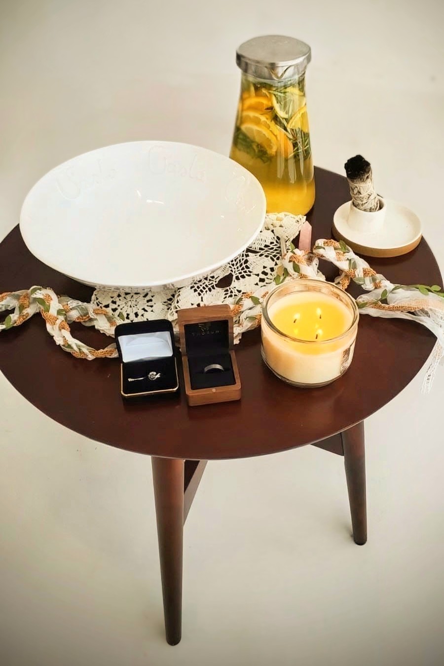Mesa ceremonial con cuenco, agua infusionada, vela y elementos simbólicos