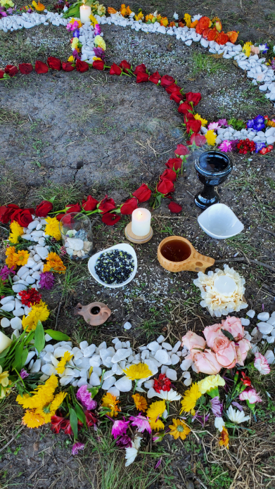 Heart-shaped floral Mayan ceremony arrangement with candles and ritual elements