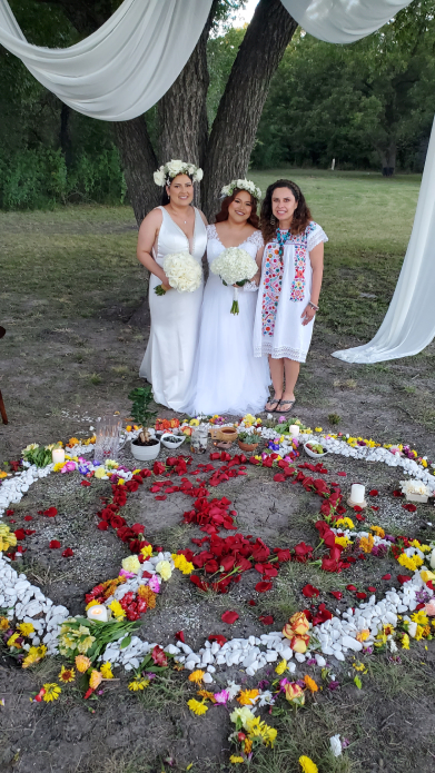 Wedding group photo with brides and oficiant beside Mayan floral ceremony circle