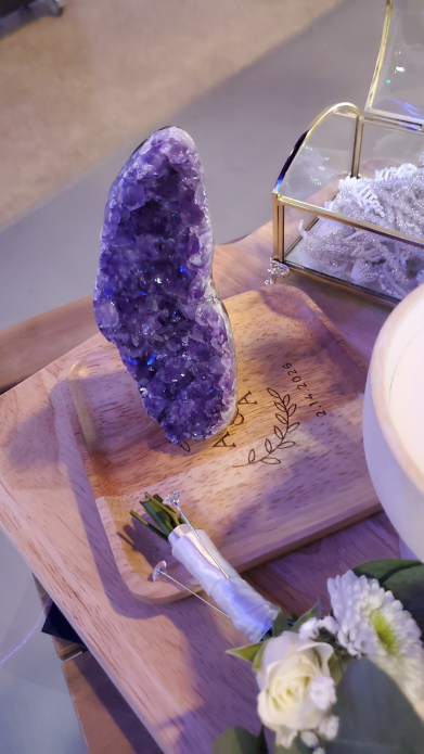 Close-up of amethyst crystal on engraved wooden board at Mayan wedding altar