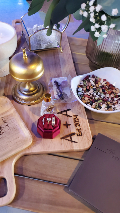 Mayan wedding altar detail with rings, candle, flowers, and engraved wooden board