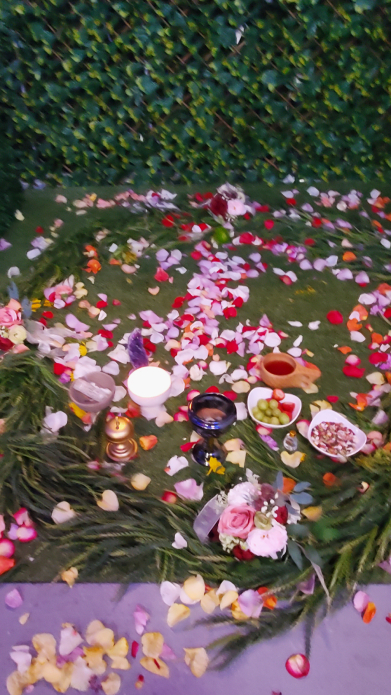 Indoor Mayan floral ceremony circle with scattered petals and candles