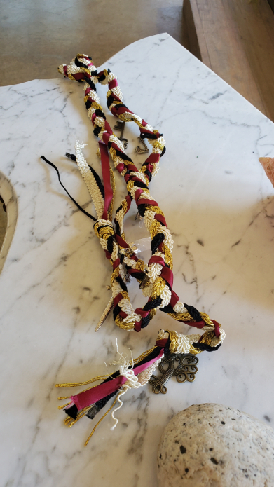 Detalle de cuerdas de handfasting en boda vikinga con cuentas y adornos simbólicos