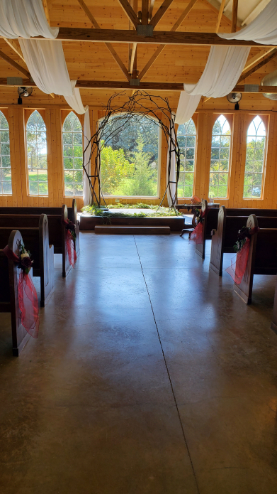 Pasillo de ceremonia de boda vikinga en interior con arco de madera y telas decorativas