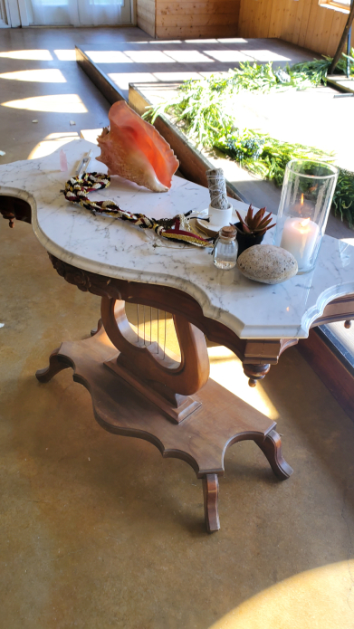 Mesa de altar de boda vikinga con vela, caracol, sahumerio y elementos ceremoniales