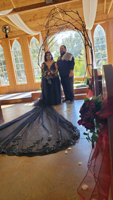 Novia y novio con vestimenta estilo vikingo en ceremonia bajo arco de madera