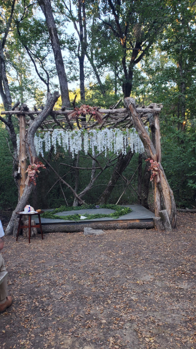 Altar de boda vikinga al aire libre con estructura de madera rústica y arreglos florales