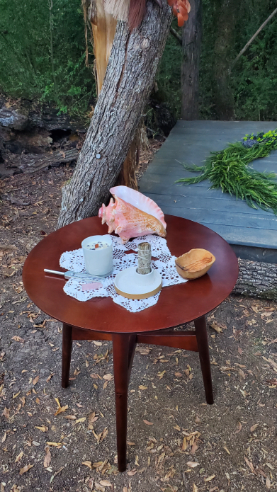 Mesa de ritual vikingo al aire libre con caracol, vela y objetos ceremoniales